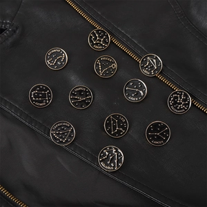Détails des broches dorées du zodiaque sur le revers d'une veste en cuir noir élégante