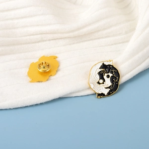 Detail of yin yang wolf enamel pin showing golden finish and butterfly clutch back