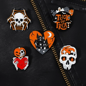 Close-up of Halloween enamel pins featuring skeleton, pumpkin, and bat designs on leather
