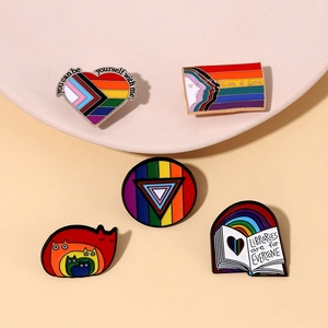 Detaillierte Makroansicht von 5 Emaille-Pins im Regenbogen-Design auf einem Tablett