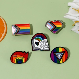 Detailansicht von fünf Emaille-Pride-Ansteckern mit Regenbogen und Love is Love Text