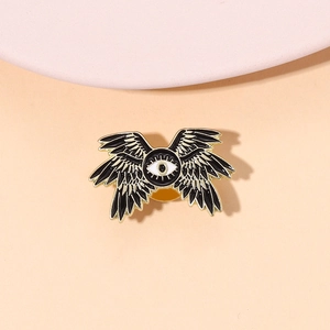 Detailed view of dark gothic eagle eye enamel pin with black and white wings