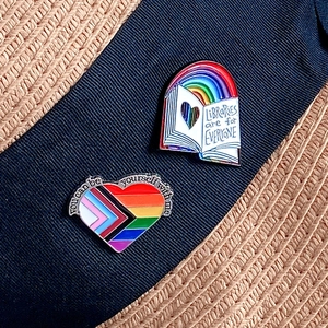 Regenbogen Herz- und Buch-Emaille-Pins mit inklusivem Text auf blauem Band