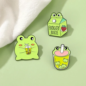 Detailed view of cute enamel frog pins with strawberry juice box and bubble tea designs