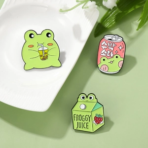 Cute cartoon frog enamel pin set with milk box and bubble tea designs on green background