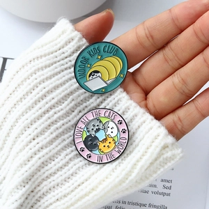 Close-up of alloy enamel pins with cute cartoon cat club designs on white sweater