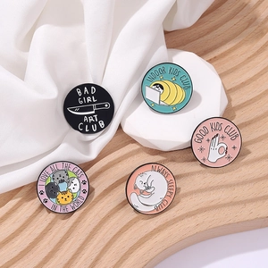 Set of five cartoon club enamel pins featuring cats and typography on white fabric