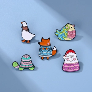Detail view of five cartoon animal enamel pins featuring fox and goose on light blue background
