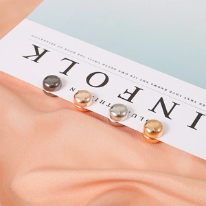 Dettaglio di clip magnetiche per foulard in finiture metalliche oro, argento e rosa
