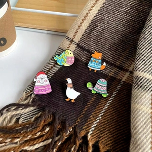 Set of 5 cartoon animal enamel pins featuring a fox, cat, and goose on plaid fabric