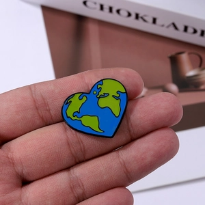 Blue heart-shaped Earth enamel brooch held by hand for clothing and bag decoration