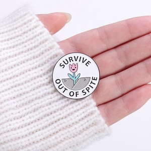 Creative round flower enamel brooch with Survive Out Of Spite slogan on white sweater