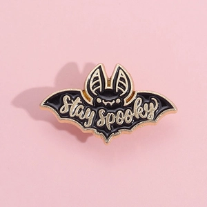 Vue détaillée du pin's chauve-souris en émail noir avec lettrage doré Stay Spooky