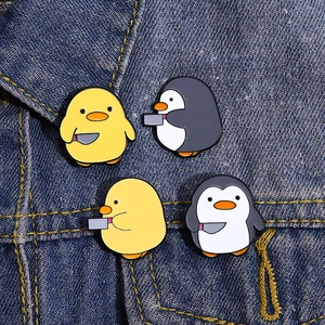 Détail de quatre épingles en émail d'animaux de dessin animé avec des couteaux sur denim