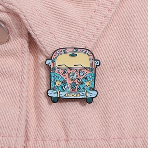 Nahaufnahme der rosa Vintage-Hippie-Bus-Emaillenadel mit Friedenszeichen auf Denim