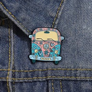 Detailansicht einer bunten Hippie-Bus-Emaille-Anstecknadel auf blauem Denim-Stoff