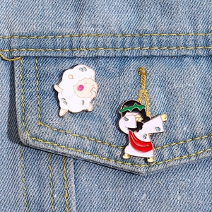 Detail von süßen Schaf- und dabbing Jesus-Emaille-Pins auf dunkelblauem Denim-Gewebe