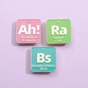 Set of three colorful science element enamel pins with Ah Ra Bs chemical symbols