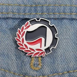 Vue détaillée du badge en émail avec feuille de laurier et engrenage sur denim