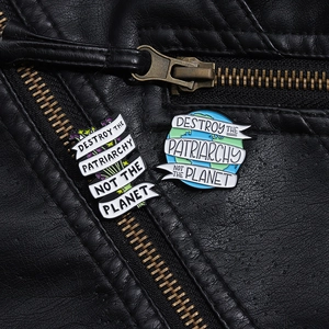 Detail van emaille pins met slogans op een zwart leren jack met metalen textuur