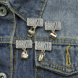 Detail of four silver coffee badges on denim jacket including coffee pot and bean