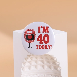 Detail of a round 40th birthday badge with red monster graphic and I'M 40 TODAY text