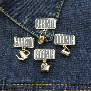 Detail of coffee-themed enamel pins featuring coffee beans and cups on denim background