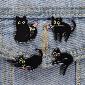 Lot de quatre pin's chat noir avec roses roses sur fond de tissu en denim