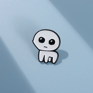 Macro shot of white TBH Creature enamel pin with zinc alloy base on blue surface