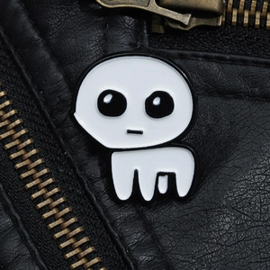 Detailed view of white TBH Creature enamel pin on a black leather jacket with zipper