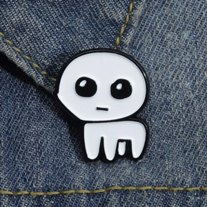 Close-up of a white enamel TBH Creature pin on denim fabric showing metal details