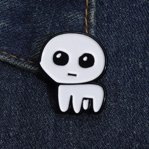 Close-up of TBH Creature enamel pin with white filling on dark blue denim fabric