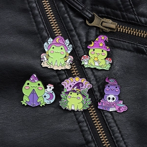 Detaillierte Nahaufnahme von 5 magischen Frosch-Emaille-Pins auf einer Lederjacke