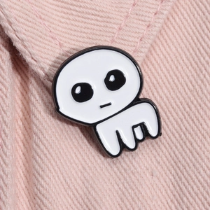 Macro shot of white TBH Autism Creature enamel pin attached to pink denim fabric texture