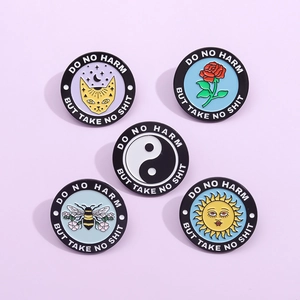 Set of five enamel pins with cat, rose, bee and sun motifs with slogan engraving