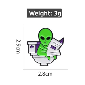 Funny alien enamel pin on toilet reading newspaper with dimensions 2.9cm x 2.8cm