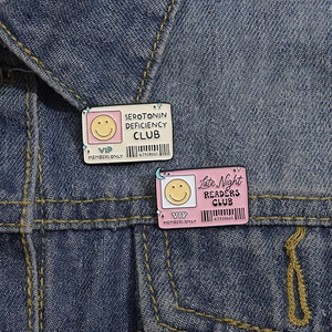 Cartoon Serotonin and Reader Club enamel pins on blue denim jacket with smileys