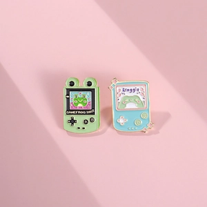 Cute game console enamel pins set featuring green and blue cartoon frog designs