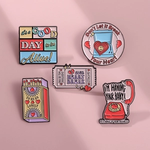 Flat lay of retro enamel pins set featuring matchbox and vintage telephone designs