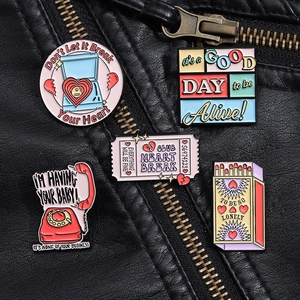 Close-up of five colorful vintage enamel pins featuring retro phone and matchbox shapes