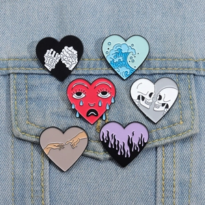 Set of 6 creative heart enamel pins featuring skull, ocean wave and art motifs on denim