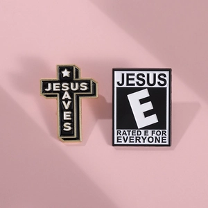 Detail view of Jesus Saves cross and ESRB style Jesus enamel pins on pink background