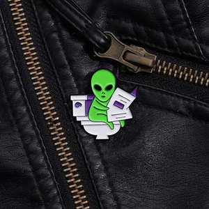 Close-up of funny ET alien enamel pin on a black leather jacket collar for styling
