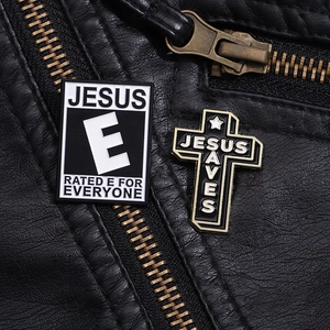 Detailed close-up of Jesus Saves cross and Jesus letter pins on black leather jacket