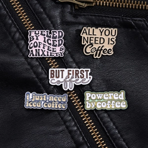 Nahaufnahme von kreativen Kaffee-Emaille-Pins an einer schwarzen Lederjacke im Detail
