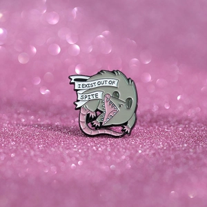 Detailed close-up of cartoon opossum enamel pin with I Exist Out Of Spite text
