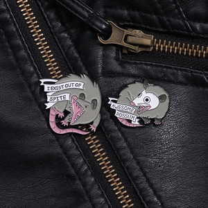 Detail view of funny opossum enamel pins on black leather jacket with witty text