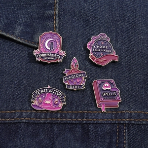 Detail of five magical purple enamel pins including a wizard hat and owl on denim fabric