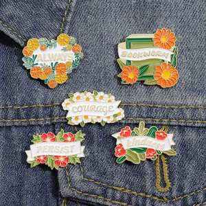 Detailed view of colorful floral enamel pins pinned on a classic blue denim jacket pocket