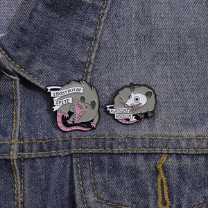 Funny possum enamel pins set on denim jacket featuring unique illustrated slogans